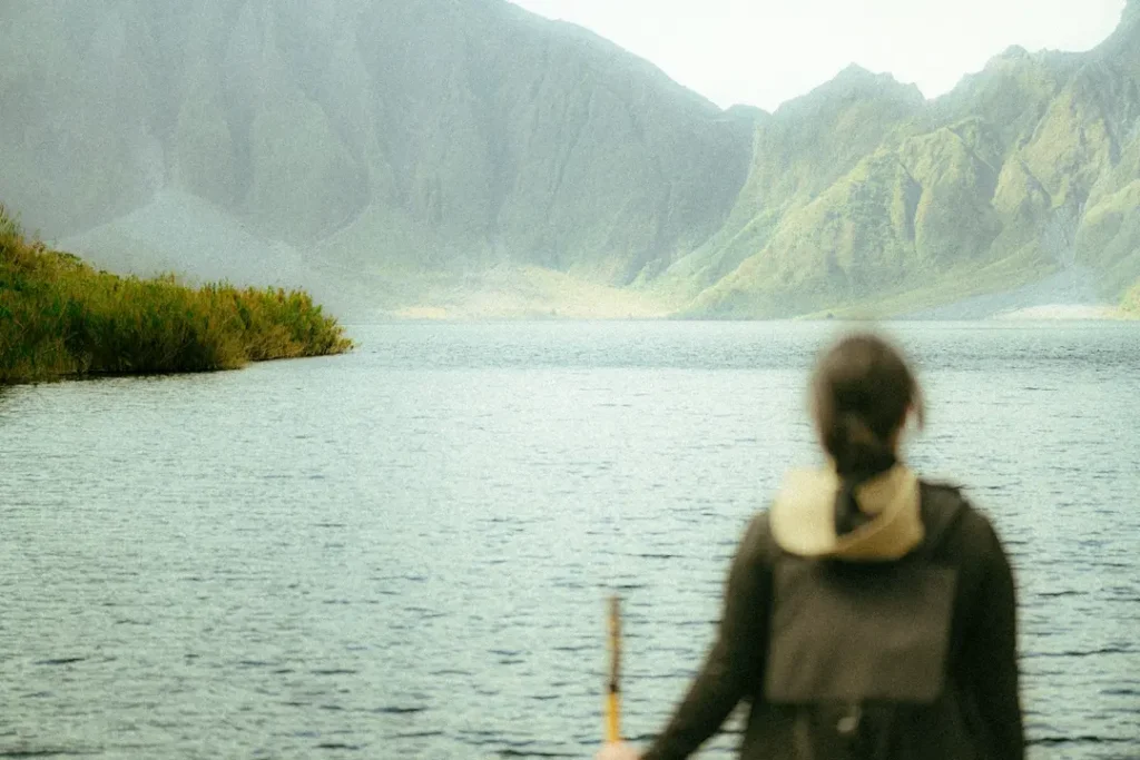 Hiker embracing stillness in nature, embodying effortless exploration and Dao philosophy
