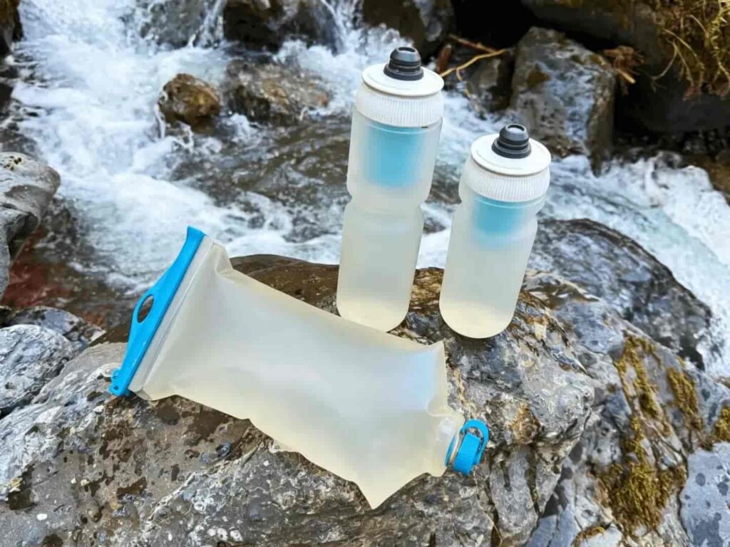 water bottle resting on wet stone beside a gently flowing backcountry stream, wu wei