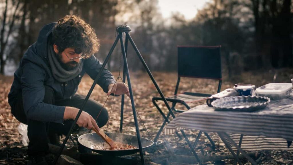 A lone hiker practicing minimalist backcountry cooking over a gentle campfire during golden hour, nourishing Qi.